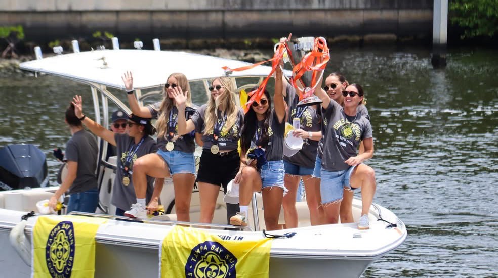 Tampa Bay Sun FC's players bring the trophy up the Hillsborough River during their boat parade after winning the inaugural USL Super League title.